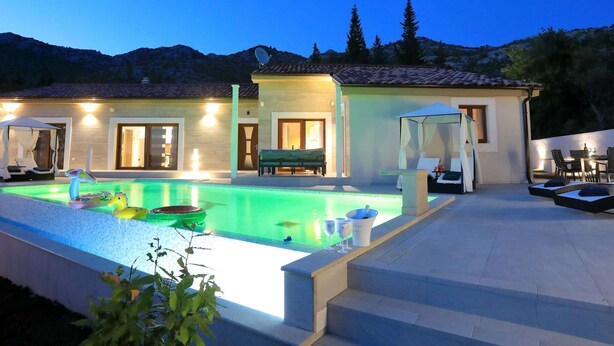 A poolside area with a pool, lounge chairs, and a covered seating area. - Villa in Starigrad With Heated Pool (Starigrad)