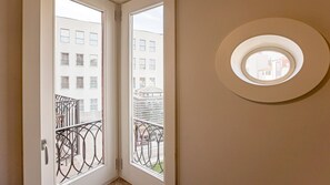 A room with a door leading to a balcony with metal railings and a view of buildings. - Palácio das Cardosas Studio by LovelyStay (Porto)
