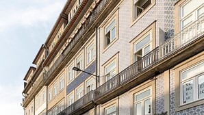 Ein mehrstöckiges Gebäude im traditionellen Baustil mit aufwendigen Balkonen und verzierten Fensterrahmen.