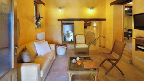 A cozy living room with a sofa, chairs, a coffee table, and a fireplace. - Holiday Home in Pontano With Garden (Sant'Angelo in Pontano)