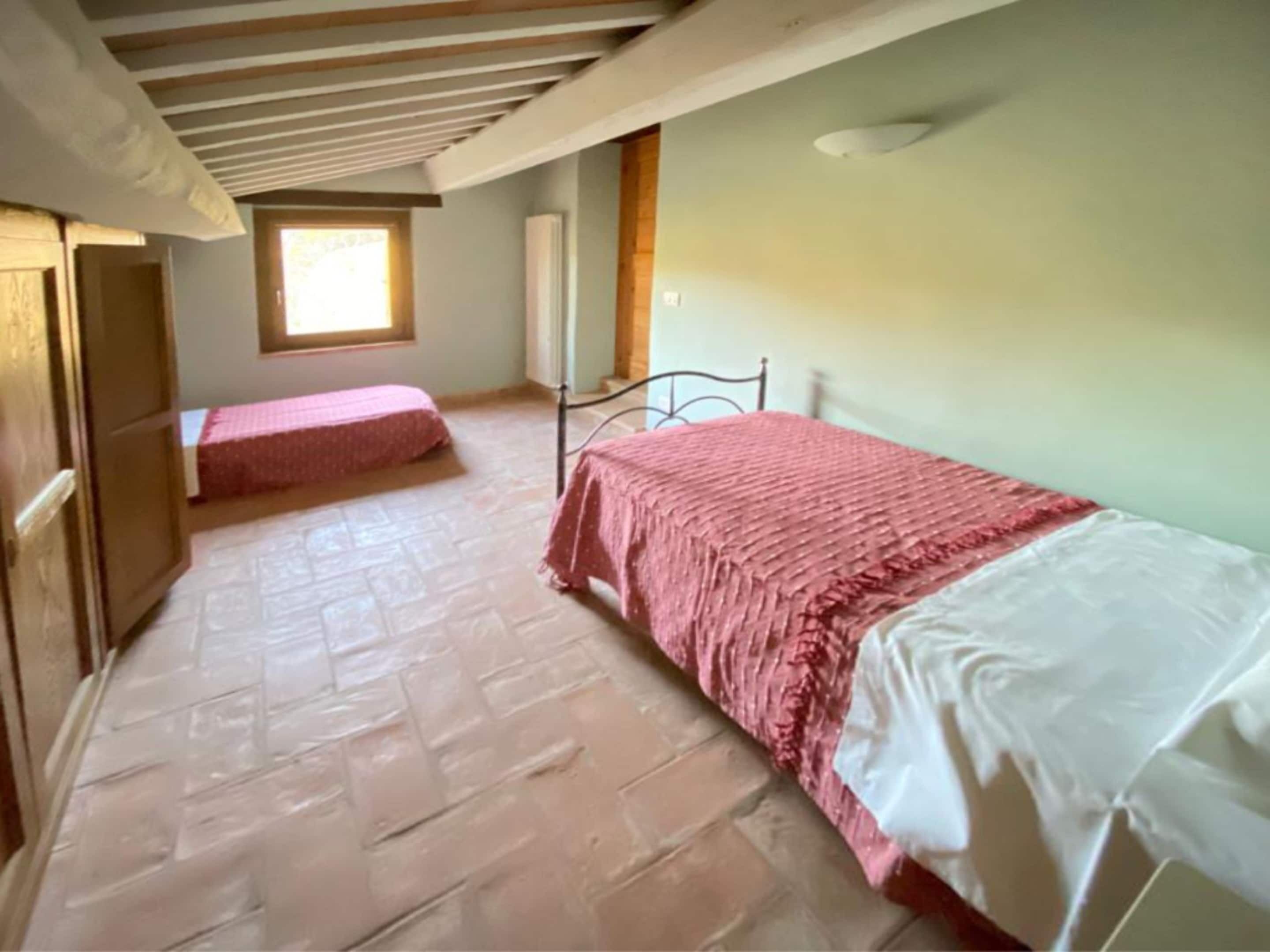 A room with a bed, a window, and a radiator.
