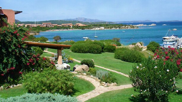 A coastal landscape with a clear view of the sea, boats, and a well-maintained garden with a pergola. - Belvilla by OYO Marineledda Trilocale 1 (Golfo Aranci)