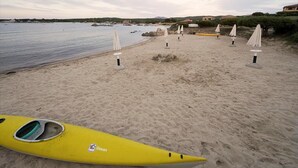 A beach with kayaks and umbrellas. - Apartment Near Golfo di Cugnana (Olbia)
