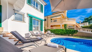 Un espace aménagé au bord de la piscine, avec des chaises longues et une piscine.