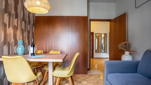 Een moderne eetruimte met een houten tafel, gele stoelen en een blauwe vaas.