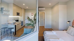 Una habitación de hotel moderna con kitchenette, comedor y dormitorio separado.