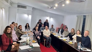 A conference room with a long table, chairs, and a projector. - Hotel Novera (Timisoara)
