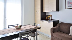 A modern kitchen with light wood cabinets, a black countertop, and a framed artwork above the sink. - Apartment at Lago di Como Near Dervio Beach (Dervio)