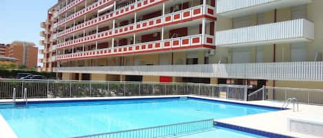 A multi-story hotel with a swimming pool.