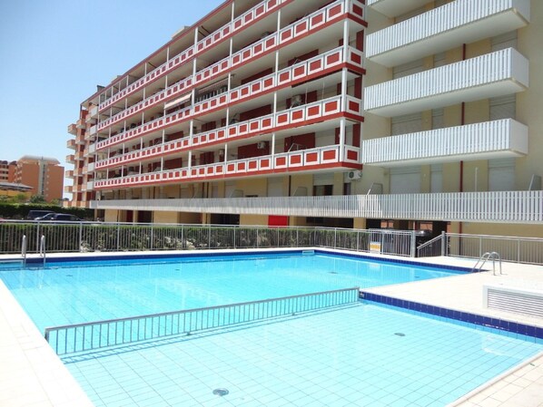 A multi-story hotel with a swimming pool.