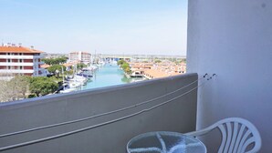 A balcony with a view of a marina and buildings. - Holiday Home Caorle Near Beach (Caorle)