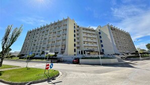 A large, multi-story hotel with a modern architectural design, featuring balconies and a central courtyard. - Holiday Home Caorle Near Beach (Caorle)