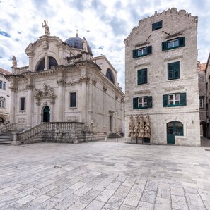 A historic building with a grand entrance, a dome, and a statue on top. - Old Town Finest - Two-bedroom Apartment - Lucarica 4 Street (Dubrovnik)