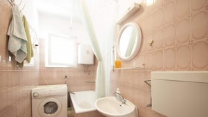 A compact bathroom with a washing machine, sink, and toilet. - Apartments Mira - One Bedroom Apartment With Balcony (Supetar)
