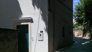 A narrow street with a building entrance, a door, and a small sign indicating a room number. - Apartment Tranquilo- Two Bedroom Apartment With Garden View (Dubrovnik)
