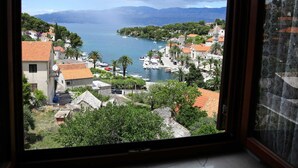 Eine Küstenstadt mit Gebäuden, Booten und Bergen im Hintergrund.