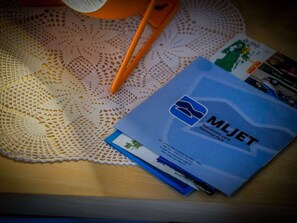 A brochure titled "National Park" on a wooden table with a lace doily and orange scissors.