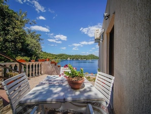 A terrace with a table, chairs, and potted plants.