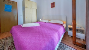 A bedroom with a bed, a wardrobe, a bedside table, and a hanging light fixture. - Apartments Filipovic - One Bedroom Apartment With Terrace and Sea View (Mljet)