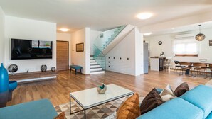 A spacious living room with a staircase leading to a kitchen and dining area. - Apartment in Croatia Near the Coast (Liznjan)