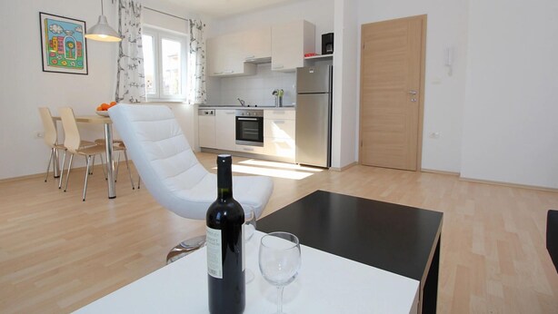 A modern apartment with a dining area, kitchen, and a living space. - Apartment in Premantura Near Kamenjak Park (Medulin)