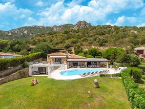 A villa with a swimming pool, outdoor seating, and a view of the surrounding hills. - Luxe Cote Stay- Elegant Villa (Arzachena)