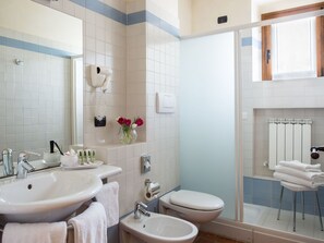 Ein Badezimmer mit Waschbecken, Bidet, Toilette und Duschbereich.