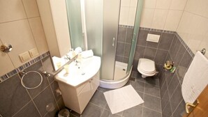 A bathroom with a shower, toilet, sink, and a towel rack. - Apartments Villa Grlica - One Bedroom Apartment With Balcony and Garden View (Sutivan)