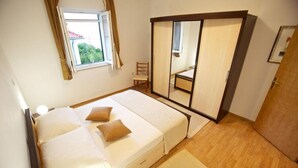 A bedroom with a bed, a mirror, a chair, and a window. - Apartments Villa Grlica - One Bedroom Apartment With Balcony and Garden View (Sutivan)