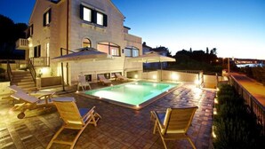 A two-story house with a swimming pool, outdoor seating, and a view of the sea. - Apartments Villa Grlica - One Bedroom Apartment With Balcony and Garden View (Sutivan)
