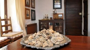 A dining table with a plate of cookies in a room with wooden furniture and framed pictures on the wall. - House Rilovic - Two Bedroom House With Swimming Pool and Jacuzzi (Konavle)