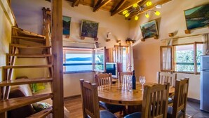 A wooden dining area with a table and chairs, a staircase, and a view of the sea through a window. - Villa Sea Edge - Three Bedroom Villa With Sea View (Orebic)