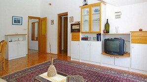 A living room with a sofa, a television, and a cabinet with glass doors. - Apartments Tomasic - Two Bedroom Apartment With Terrace and Sea View (Smokvica)