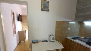 A compact kitchen with a small table, a kettle, and basic amenities. - Apartments Vinko Mljet- One-bedroom Apartment With Terrace (Mljet)