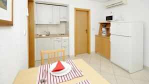 A compact kitchen with white cabinets, a microwave, and a refrigerator. - Apartments Villa Moonlight - One Bedroom Apartment With Sea View Balcony and Terrace (Okrug)