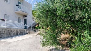 A white building with a balcony and a staircase leading to the entrance. - Apartment Konak - Two Bedroom Apartment With Balcony and Sea View (Konavle)