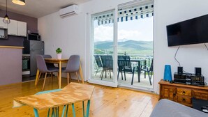 A modern apartment with a kitchen, dining area, and a balcony with a mountain view. - Apartment Konak - Two Bedroom Apartment With Balcony and Sea View (Konavle)
