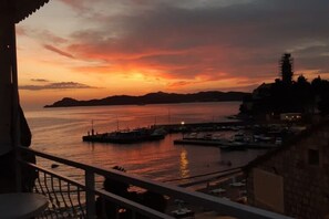 A sunset view from a balcony overlooking a marina with boats and a distant island. - Rooms Milena - Double or Twin Room With External Private Bathroom (Dubrovnik)