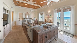A spacious living area with a ceiling fan, a wooden cabinet, and a view of the ocean. - Stunning Gulf Front! Private Pool & Beach Access | Inquire for Specials! (Miramar Beach)
