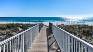 A wooden boardwalk leading to a beach with clear blue water and sandy dunes. - Stunning Gulf Front! Private Pool & Beach Access | Inquire for Specials! (Miramar Beach)