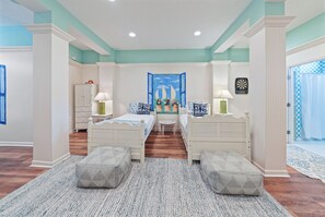 A bedroom with two beds, a blue and white patterned rug, and a nautical-themed tapestry. - Stunning Gulf Front! Private Pool & Beach Access | Inquire for Specials! (Miramar Beach)