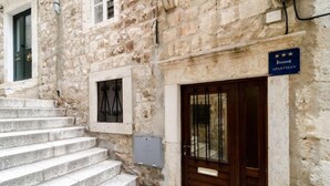 Un bâtiment en pierre avec une porte en bois et une enseigne indiquant qu’il s’agit d’un appartement.