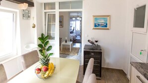 A modern kitchen with a dining table, a fruit bowl, and a wine cooler. - Apartments Tino- Two Bedroom Apartment With Balcony and Sea View (Sutivan)