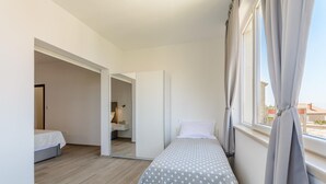A bedroom with a bed, a small bedside table, a mirror, and a window with curtains. - Apartment Marcela - Deluxe Two Bedroom Apartment With Terrace and Sea View (Sutivan)