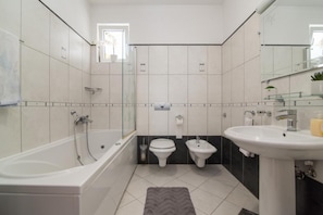 Un baño moderno con bañera, inodoro, bidé y lavamanos.