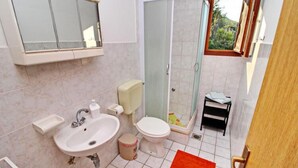 A bathroom with a sink, toilet, and shower.
