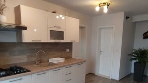 A modern kitchen with white cabinets, a wooden countertop, and a built-in oven. - Holiday Home Luna - Two Bedroom Holiday Home With Sea View (Korcula)