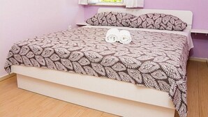 A bed with a patterned bedspread and two rolled towels on it. - Apartments Stella - One Bedroom Apartment With Terrace A2 (Dubrovnik)