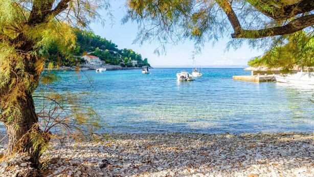 A coastal scene with clear water, boats, and pebbled beach. - Vacation House Marija, Korcula-two Bedroom Holiday Home With Terrace and Sea View (Korcula)