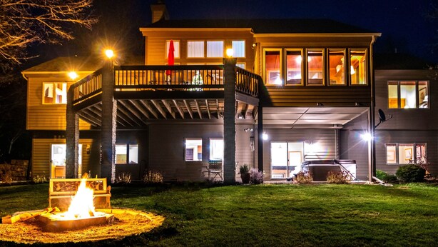 A two-story house with a covered patio and a fire pit in the front yard. - Gorgeous View, HotTub, Great Games, Stories Around the Fire! (Guilford Township)
